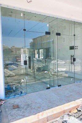 معلم زجاج القصيم أثناء العمل على تركيب واجهة زجاجية